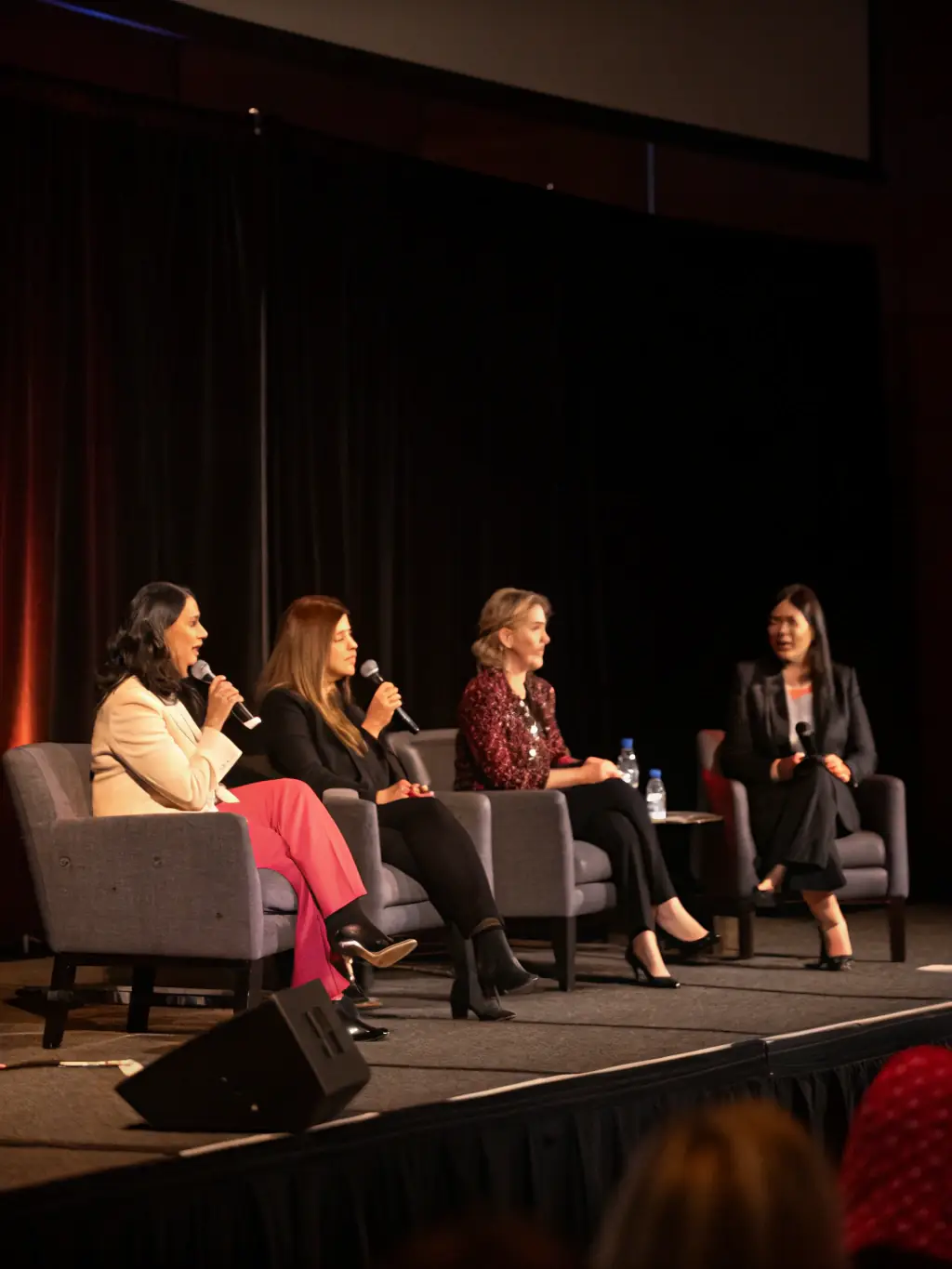 A dynamic image of a panel discussion featuring diverse feminist speakers at the Feminisms & Podcasts Festival, engaging in a lively debate.
