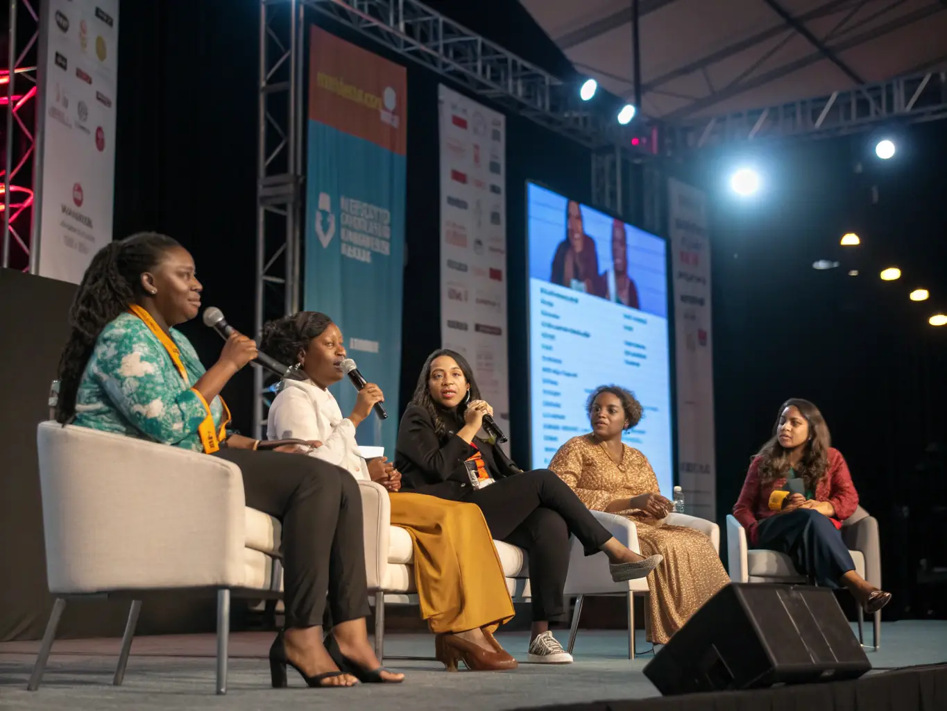 A photograph capturing a panel discussion at the Feminisms & Podcasts Festival, featuring diverse speakers engaging in a lively conversation about feminist issues.